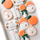 a little cutie on the way, orange rattle, bib, swaddled baby, romper, baby shower cookies