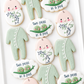two peas in a pod, swaddled baby, crib mobile, footed pajamas, cat toy, baby shower cookies