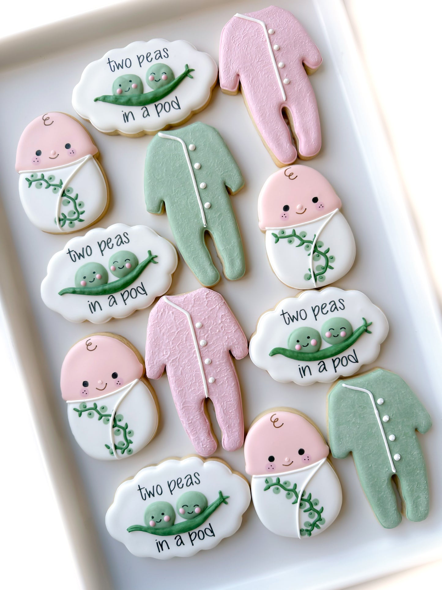 two peas in a pod, swaddled baby, crib mobile, footed pajamas, cat toy, baby shower cookies